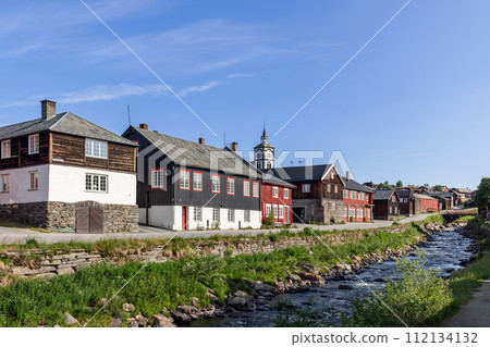 Harmonious riverside setting in Roros with its historic wooden architecture, prominent church tower Harmonious riverside setting in Roros with its historic wooden architecture, prominent church tower 112134132