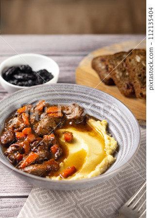 Meat with prunes, goulash and mashed potatoes vertical tasty Meat with prunes, goulash and mashed potatoes vertical tasty 112135404