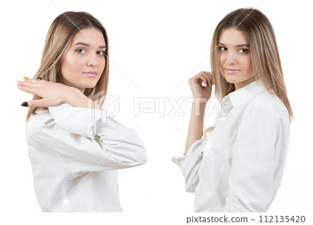Two identical girls in a white blouse. Twin sisters on a white background. Two identical girls in a white blouse. Twin sisters on a white background. 112135420