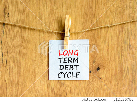 Long term debt cycle symbol. Concept words Long term debt cycle on beautiful white paper on clothespin. Beautiful wooden background. Business Long term debt cycle concept. Copy space. Long term debt cycle symbol. Concept words Long term debt cycle on beautiful white paper on clothespin. Beautiful wooden background. Business Long term debt cycle concept. Copy space. 112136793