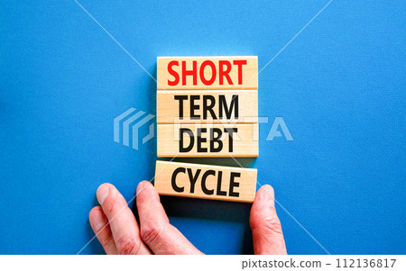 Short term debt cycle symbol. Concept words Short term debt cycle on beautiful wooden block. Beautiful blue table background. Businessman hand. Business Short term debt cycle concept. Copy space. 112136817