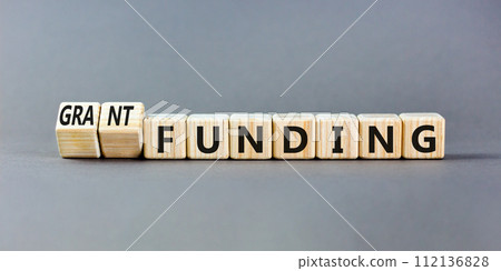 Grant funding symbol. Concept words Grant funding on beautiful wooden blocks. Beautiful grey table grey background. Business and grant funding concept. Copy space. 112136828