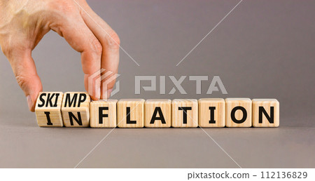 Inflation or skimpflation symbol. Concept words Inflation Skimpflation on beautiful wooden blocks. Beautiful grey background. Businessman hand. Business inflation skimpflation concept. Copy space 112136829