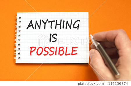 Anything is possible symbol. Concept words Anything is possible on beautiful white note. Beautiful orange background. Businessman hand. Business anything possible concept. Copy space. 112136874