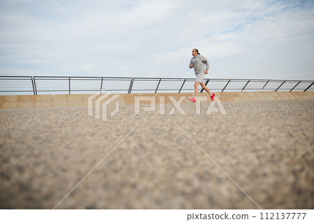 Full size portrait athletic man running in the city. Copy advertising space. Running. Jogging. Sprinting. Cardio workout Full size portrait athletic man running in the city. Copy advertising space. Running. Jogging. Sprinting. Cardio workout 112137777