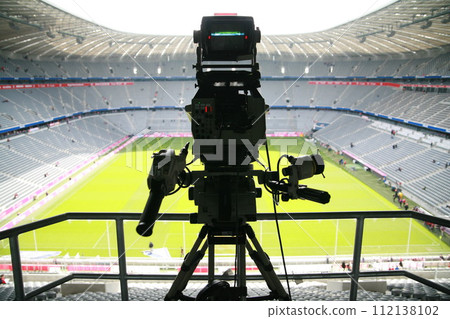 A camera is set up on a tripod in a stadium 112138102