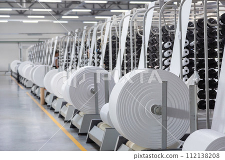 Interior of a factory workshop for the production of polypropylene bags. Racks with rolls and coils. Interior of a factory workshop for the production of polypropylene bags. Racks with rolls and coils. 112138208