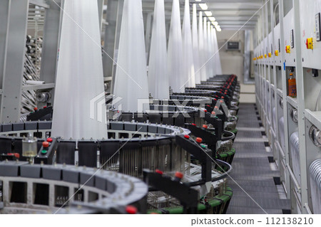 Interior of a factory shop. Equipment for weaving polypropylene fabric. 112138210