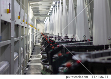 Interior of a factory shop. Equipment for weaving polypropylene fabric. Interior of a factory shop. Equipment for weaving polypropylene fabric. 112138211