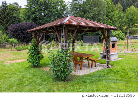 wooden gazebo and table on grass 112138590