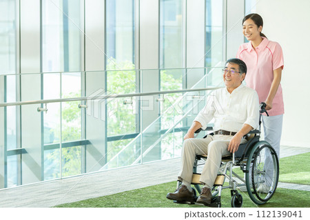 Senior in wheelchair and young female caregiver Senior in wheelchair and young female caregiver 112139041