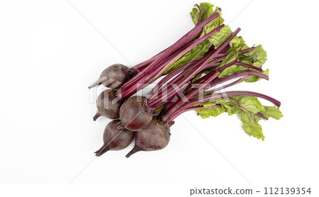 A pile of red young beets on a white table. The view from above. Fresh beets. A pile of red young beets on a white table. The view from above. Fresh beets. 112139354