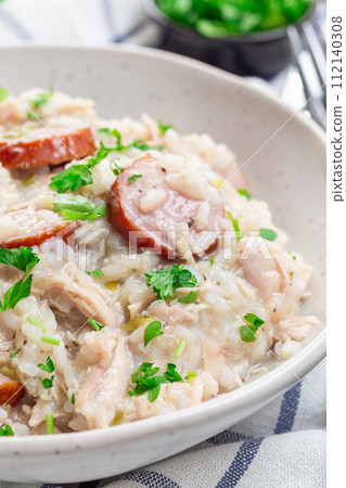 Traditional South Carolina chicken bog dish with smocked sausages, vertical closeup 112140308
