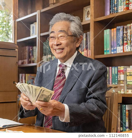 An elderly Japanese man is happily counting money. 112140855