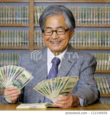 An elderly Japanese man is happily counting money. An elderly Japanese man is happily counting money. 112140856
