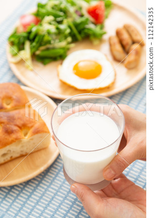 Hands of a woman eating breakfast of milk and bread Hands of a woman eating breakfast of milk and bread 112142335