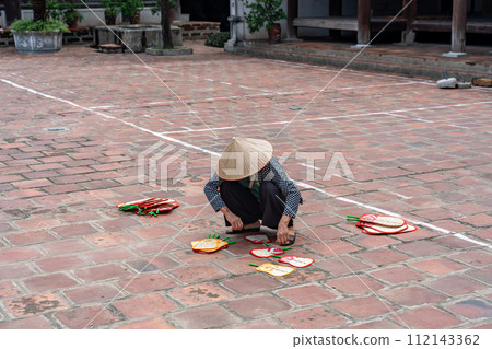 A person blows a fan in the garden of Mong Phu Pavilion in Dong Lam village, which is designated as a national cultural property in Hanoi, Vietnam. 112143362