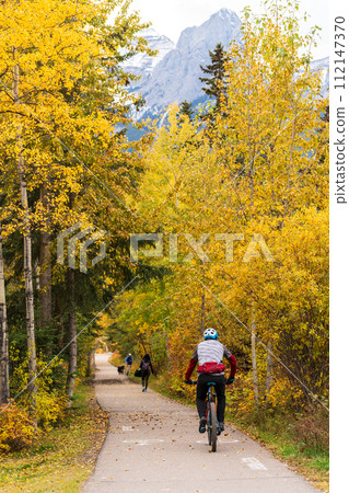 People walking and cycling on the Spur Line Trail in fall season. Canmore, Alberta, Canada. People walking and cycling on the Spur Line Trail in fall season. Canmore, Alberta, Canada. 112147370