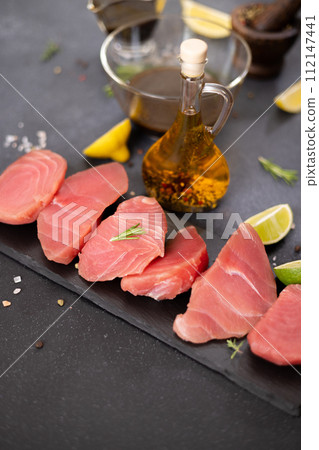 Pieces of Fresh tuna Fish fillet and soy sauce marinade in a glass bowl 112147441