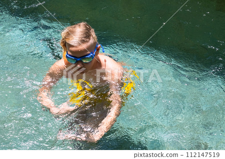 Teenage boy playing in swimming pool. 112147519