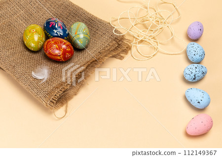 Easter eggs on a sackcloth bag on the beige background. Easter eggs on a sackcloth bag on the beige background. 112149367