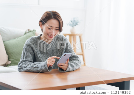 穿著冬衣的女人使用智慧型手機 穿著冬衣的女人使用智慧型手機 112149392
