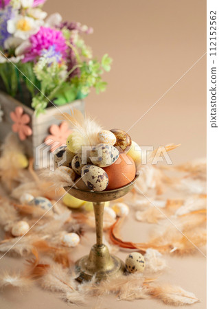 Easter composition with eggs, feathers, and spring flowers. 112152562
