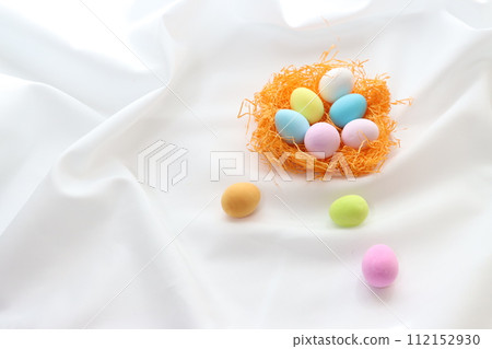 Clay-crafted colorful eggs inside an orange bird's nest 112152930