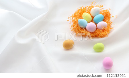 Clay-crafted colorful eggs inside an orange bird's nest 112152931