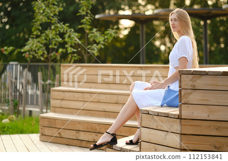 Young woman sitting on bench Young woman sitting on bench 112153841