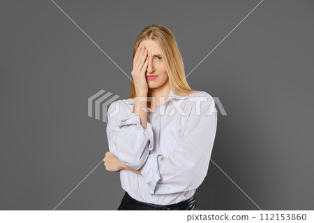 Portrait of a tired woman covering one eye with her palm 112153860