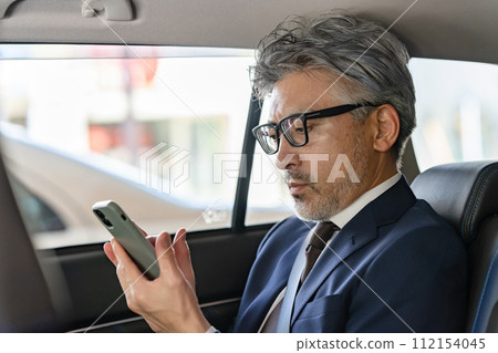 Senior male business car smartphone 112154045