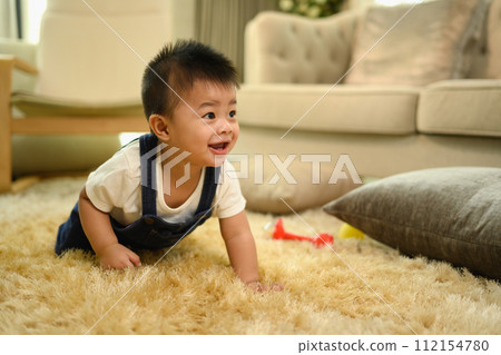Cute little baby boy crawling on the carpet in cozy living room 112154780