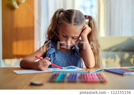 Concentrated girl painting with colorful pencils Concentrated girl painting with colorful pencils 112155156