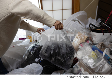 A middle-aged woman organizing her parents' house A middle-aged woman organizing her parents' house 112155298
