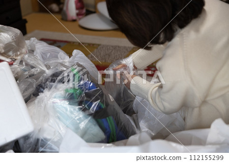 一位中年婦女正在整理父母的房子 一位中年婦女正在整理父母的房子 112155299