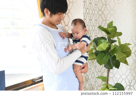 Asian male nursery teacher holding an infant 112155997