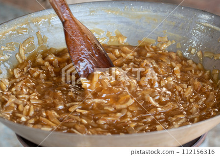 thin coconut flakes fried in sugar syrup thin coconut flakes fried in sugar syrup 112156316