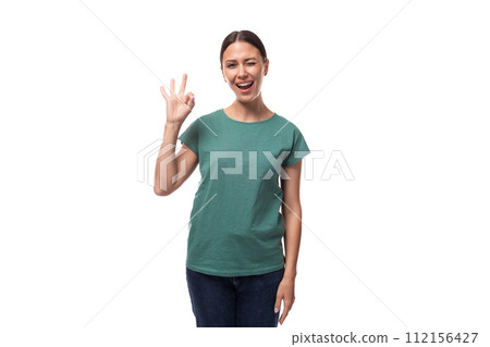 young joyful positive black-haired woman in a green basic t-shirt on a white background with copy young joyful positive black-haired woman in a green basic t-shirt on a white background with copy 112156427