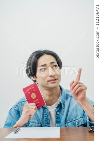 young man holding a passport young man holding a passport 112156471
