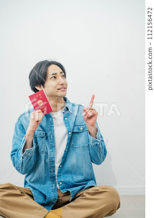 young man holding a passport 112156472