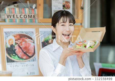 A woman buying lunch from a kitchen car 112156499