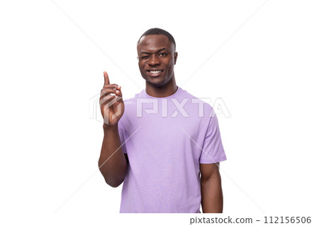 young successful american man dressed in a light lilac t-shirt on a white background with copy space young successful american man dressed in a light lilac t-shirt on a white background with copy space 112156506