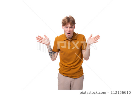 young fashionable student man with short red hair dressed in a yellow t-shirt is actively gesturing 112156610