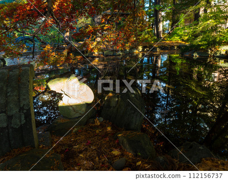 Light shines on stone ornaments in a Japanese garden in autumn Light shines on stone ornaments in a Japanese garden in autumn 112156737