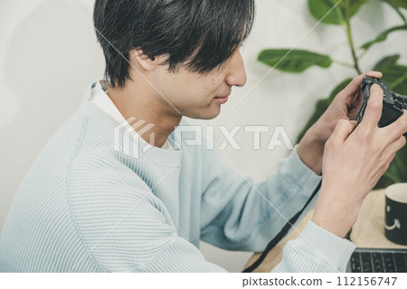 年輕人檢查用相機拍攝的照片 年輕人檢查用相機拍攝的照片 112156747
