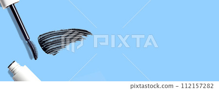 swatch, mascara brushstroke smear, mascara brush composition cosmetic on blue background flat lay banner copy space 112157282