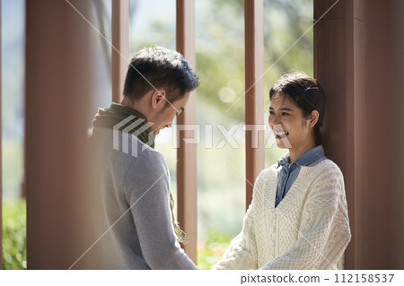 young asian couple talking chatting outdoors in city park young asian couple talking chatting outdoors in city park 112158537