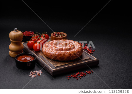 Delicious grilled sausage in the form of a ring with salt, spices and herbs 112159338