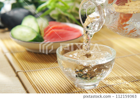 倒入清酒並醃製黃瓜和紅蘿蔔 倒入清酒並醃製黃瓜和紅蘿蔔 112159363